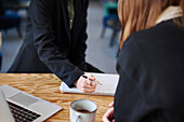 Mid section of woman sitting in office