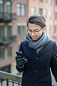 Handsome man with smartphone on street