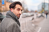 Elegant man with earbuds on street