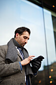 Mid adult businessman using phone outdoors