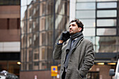 Businessman talking on phone in city