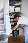 Woman putting basket in wardrobe