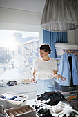 Woman folding clothes on bed