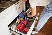 High angle view of woman cleaning kitchen drawer