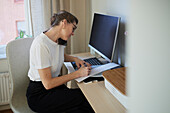 Woman at desk using cell phone