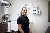 Female dentist standing in office