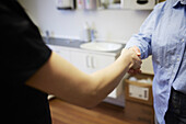 Handshake of dentist and patient, mid section