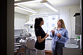 Female dentist talking to patient in office