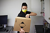 Female dentist in surgery opening cardboard box