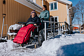 Mother having winter walk with daughter in wheelchair