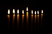 Kerzenreihe vor schwarzem Hintergrund