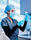 Krankenschwester mit Gesichtsmaske und Schutzschild bei der Vorbereitung der Covid-19-Impfung
