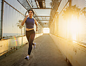 Frau joggt bei Sonnenuntergang