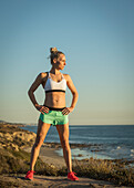 Vereinigte Staaten, Kalifornien, Laguna Beach, Sportliche Frau in Sportkleidung steht am Strand