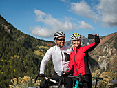 United States, Utah, American Fork, Smiling couple with bicycles taking selfie in mountain landscape