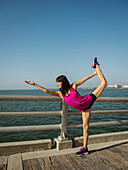 Frau beim Stretching auf einer Brücke an einem sonnigen Tag