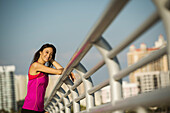 Vereinigte Staaten, Florida, Sarasota, Portrait einer lächelnden Frau in Sportkleidung auf einer Brücke an einem sonnigen Tag