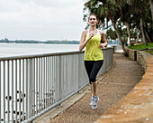 Vereinigte Staaten, Florida, Tampa, Frau joggt auf Fußweg am Fluss