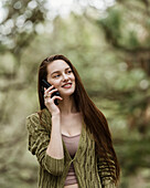 Smiling woman talking on phone in park