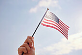 Hand hält amerikanische Flagge
