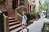 USA, New York, New York City, Junge geht in einem Wohnviertel spazieren