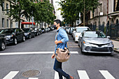USA, New York, New York City, Man in face mask crossing street in city