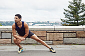 USA, New York, New York City, Man in sports clothing stretching outdoors