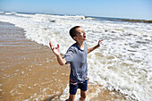 Smiling boy (8-9) in sea waves