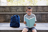 USA, New York, New York City, Boy (8-9) with backpack running up school steps