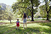 USA, New York, New York City, Rear view of mother and daughter (2-3) playing in park