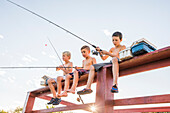 Tiefblick auf hemdlose Jungen (8-9) beim Angeln am See
