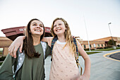 United States, Utah, Lehi, Smiling sisters (10-11, 12-13) in front of school building
