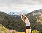 Vereinigte Staaten, Utah, American Fork, Rückansicht einer sich streckenden Frau in einer Berglandschaft