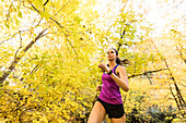 Frau joggt im Herbstwald