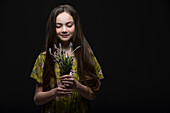 Studio portrait of smiling girl (10-11) holding bunch of grape hyacinths