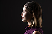 Profil einer Frau vor schwarzem Hintergrund