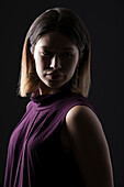 Studio-Porträt einer Frau in ärmellosem lila Oberteil