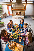 Familie mit Kindern (10-11, 12-13, 16-17) isst zu Abend