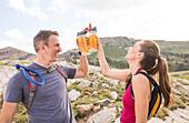 United States, Utah, Alpine, Smiling hiking couple raising toast with energy drinks