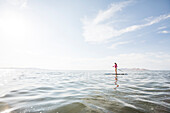 Frau paddelt auf einem See