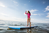 Woman standing on paddleboard in lake