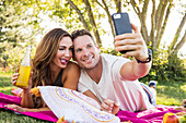 Lächelndes Paar macht Selfie im Park