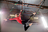Young acrobat performing on aerial hoop
