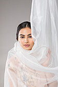 Beautiful woman wrapped in tulle fabric