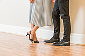 Niedriger Ausschnitt eines Paares, das auf einem Holzboden in einer Wohnung steht 