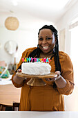 Smiling woman holding birthday cake