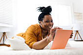 Smiling woman reading book in bed