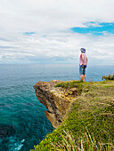 Australien, New South Wales, Port Macquarie, Frau steht auf einer Klippe und blickt in die Ferne 