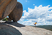 Australien, Queensland, Girraween National Park, Mann übt neben einem großen Felsblock