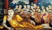 Myanmar, Mandalay, Reclining Buddha statue and paintings in Buddhist temple